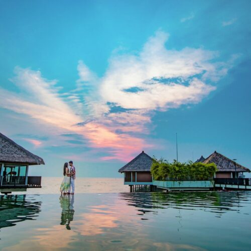 man and woman standing beside beach
