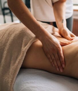 A serene massage session indoors highlighting hands-on body care and relaxation.